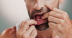 Dental health, hands and man with floss in studio for cleaning, hygiene or morning mouth routine. Oral care, grooming and male person with teeth string to prevent gum disease by gray background