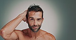 Smile, man and face with hair care in studio, wellness or satisfaction with collagen treatment. Mockup space, male person or portrait with touching for cosmetics benefits, grooming or gray background
