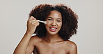 Studio, woman and brush for makeup, smile or foundation for skin with cosmetics, face or happy. White background, glow and application of powder with tools, beauty or person with routine for makeover