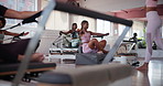 Challenge, personal trainer and workout group in class for instruction, exercise or performance. Fitness, reformer machine and woman coaching students in gym for development or strength improvement