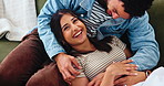 Smile, couple and tickle in home, laugh or bonding together with partner for love. Funny, woman and playful man on sofa to relax for romantic game, connection and holding hands for relationship above