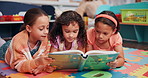 Education, group and children with book in classroom for learning, development or story time. Kids, relax and girl students reading novel on floor mat for literacy knowledge at elementary school.