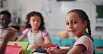 Face, students and writing with girl in classroom for future, education and youth. Learning, academy and knowledge with group of kids at school for child development, studying and happiness together