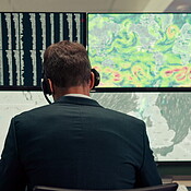 Man Climate Control Computer Man, computer and screen with maps in control room, monitor weather and ...