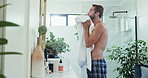 Man, wash face and towel in bathroom with drying for skincare, hygiene and wellness in morning at house. Person, mirror and cloth for cleaning, hydration and self care for cosmetics at apartment
