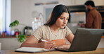 Woman, writing and ideas with laptop at house for research, schedule update and editing blog. Female person, notebook and reminder of information, article feedback and to do list of publishing agency