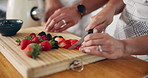 Fruit, cutting and hands of couple in kitchen for healthy eating, nutrition and breakfast drink. Home, morning and man and woman with berries for smoothie for wellness, organic diet and vitamins