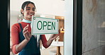 Waitress, woman and open sign by cafe door for start of day, welcome and message to public. Storefront, signage poster and happy barista with greeting for customer service, new store and advertising
