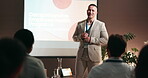 Conference, audience and businessman with mic for speech, training and workshop for employees health. Crowd, male presenter and tablet with talking for seminar, presentation and wellness for people
