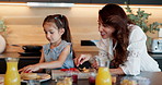 Mom, daughter and breakfast with pancakes in kitchen for dessert, meal or morning snack at home. Mother, child or little girl with fruit, orange juice or flapjacks for vitamins or nutrition at house