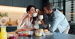 Smile, couple and drink coffee in kitchen with healthy food, nutrition fruits and morning breakfast. People, cheers and beverage with diet snacks for brunch, bonding together and marriage celebration