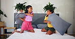 Happy, playing and kids on bed for pillow fight, bonding and sister relationship in morning. Family home, siblings and girls in bedroom for laughing, having fun and playful together for childhood