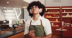 Barista, music and man with headphones in cafe for audio playlist, listening to radio and thinking. Small business, waiter and thoughtful with daydreaming, career vision and startup podcast in bistro