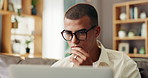 Laptop, remote work and thinking with man on sofa in living room of home for administration or planning. Computer, idea and problem solving with freelance employee in apartment for startup business