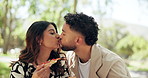 Couple, date and kiss in park with pizza, bonding and laugh with feeding. Happy people, travel and outdoor with lunch share for relationship development, weekend relax or smile for love or picnic