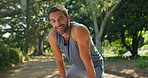 Tired, runner and man with earphones, break and workout for athlete in nature, happy and breathing. Exhausted, routine and person with music for exercise, fitness and practice for marathon or outdoor