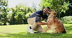 Happy, hug and man with dog in park for adventure, training and playing together outdoor. Pets, animal care and owner bonding with Golden Retriever in nature for wellness, health or exercise on grass