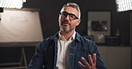 Talking, interview and face of man on set for filming with documentary, show or movie in studio. Record, discussion and journalist by lights for television public speaking with production equipment.