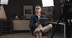 Tablet, filming and man on set with lights reading for documentary interview or podcast episode. Digital technology, research and male journalist recording for online live streaming show with script.