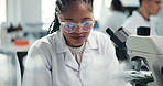 Science, lab and African woman with microscope writing notes for research, medical study or discovery. Healthcare, pharmaceutical and scientist with equipment for vaccine, microbiology and experiment