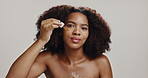Beauty, face and woman with serum in studio for skin hydration, collagen production and hyaluronic acid. Skincare, african girl and oil product for anti aging or self care routine on white background