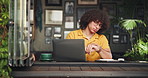 Cafe, student and man waiting on laptop for online project, digital learning and research. University, restaurant and person check time on watch for meeting, appointment or study group in coffee shop