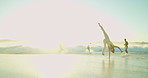 Woman, cartwheel and playful at beach with people, sunset and holiday for friends, outdoor and space in summer. Gen z girl, flip and gymnastics with group, games and sunshine on vacation by ocean