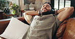 Man, headphones and relax on sofa, lying and smile with music, eyes closed and memory in living room. Person, happy and streaming with audio, subscription and listening on couch in lounge at house