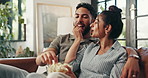 Popcorn, TV and couple relax on sofa for watching movies, film and series on streaming subscription in home. Love, snack and happy man with woman for entertainment, bonding or videos in living room