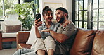Couple, phone and laugh with hug on sofa, meme and conversation with funny post on web in living room. People, man and woman with embrace, mobile app and happy for social network on couch at house