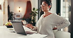 Freelancer, woman and laptop in home with back pain of bad posture, overworked or spine injury. Remote work, entrepreneur and typing on technology with ache, burnout or ergonomics mistake for tension