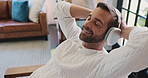 Relax, smile and man with headphones, listening and break with music in living room and comfortable. House, resting and person with tech for streaming, audio and playlist for chilling in lounge