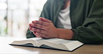 Prayer, hands and man with bible in house for religion study, worship or spiritual journey. Hope, gratitude and male person with scripture praying for peace, faith or guidance prayer in living room.