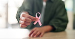 Pink ribbon, hands and woman at desk, breast cancer and healthcare with support. Awareness, community help and movement icon with disease prevention, person and recognition with symbol and empathy