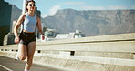 Runner, fitness and woman with running in road for marathon training, cardio exercise and performance pace. Energy, athlete and sunglasses on bridge for wellness competition, healthy body and workout