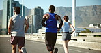 Fitness, exercise and group with running on bridge for marathon training, cardio challenge and performance pace. People, runner club and back in road for wellness competition, jog team and workout