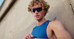 Outdoor, man and sunglasses with smart watch for fitness, check time and rest for workout by wall. Low angle, male person and runner with clock for exercise stats, health results or goal for wellness
