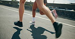 People, feet and running in city for fitness, cardio challenge and workout speed for endurance. Urban, friends and handheld on road for practice, intense exercise and marathon for muscle development