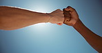 Outdoor, fist bump and men with support, below and thank you with cooperation. Blue sky, closeup and people with hand gesture, greeting and hello with nature, partnership and unity with motivation