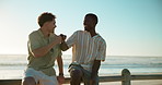 Beach, friends and men with vacation, fist bump and relax with weekend break. People, seaside and guy with summer holiday, ocean and bonding together with smile, reunion and discussion with support