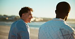 Men, friends and talking on beach outdoor for summer vacation, ocean travel and bonding. People, discussion and pointing for holiday destination, calm morning and weekend break with tropical getaway 