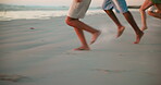 Beach, energy and feet of friends running on sand together for bonding, holiday or vacation closeup. Adventure, excited and travel with group of people outdoor on coast at ocean or sea for getaway 
