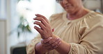 Wrist pain, home and senior woman with injury, strain and inflammation for arthritis symptoms. Retirement, health and hands of mature person with ache, spasm and medical crisis for osteoporosis