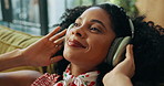 Headphones, music and happy woman relax in home, streaming sound or playlist subscription on weekend. Living room, audio technology and African person listening to favorite song, radio and podcast
