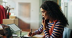 Woman, writing and phone call for small business in fashion, planning deliver and export schedule. Entrepreneur, laptop and notes at desk with communication, startup management and import logistics