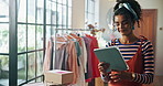 Woman, fashion designer and tablet in studio with clothes, inspection or inventory check at small business. Person, digital touchscreen and app for collection, order or boxes for shipping at workshop