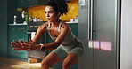Woman, training and squat with fitness, home or balance with growth for leg muscle in kitchen. Girl, workout and exercise with challenge, stretching and development for glutes in morning at apartment