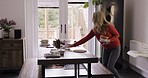 Music, cleaning and woman dance in her home while clearing dishes from a table in a living room. Radio, dining table and dancing lady clean after dinner, happy, relax and energy alone in dining area