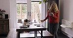 Dance, music and cleaning with a woman cleaner having fun doing housework in a home and singing. Dancing, housekeeping and chores with a homemaker tidying table with energy