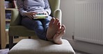Reading, relax and feet of a woman with a book in the living room of a house. Calm, mature and person at peace during retirement with books for freedom, knowledge and education in the lounge of home